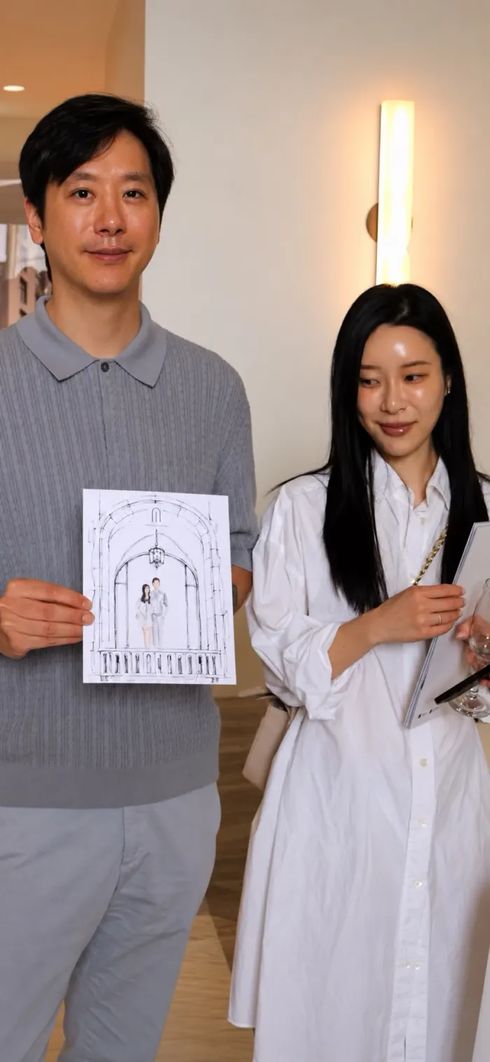 Daniel Kim holding a hand-drawn 1 Marlborough illustration with a guest at the presentation gallery
